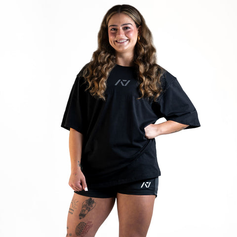 Front of the A7 Commands Overfit T-Shirt in black. Worn by a women and unisex sizing, this strength sports apparel is gym wear apparel for travelling to meets and standing on the podium 
