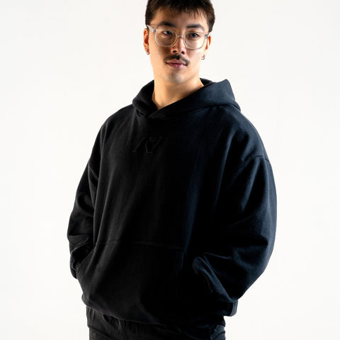 Front of the A7 Veil overfit hoodie in stealth/black. Worn by a man and unisex sizing, this strength sports apparel is meet day apparel for traveling to meets and standing on the podium 
