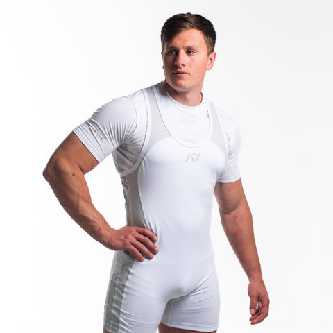 Front view of man wearing white PF approved polar singlet and polar A7 Meet t-shirt in white. Grey A7 logo on white material with light grey straps and side panels. The white A7 powerlifting singlet is made with premium materials and flatlock seams for maximum comfort on competition platform. 
