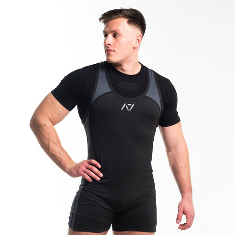 Front view of man wearing black and grey IPF approved singlet and black A7 Meet t-shirt in shadow stone colourway. Grey A7 logo on black material with grey straps and side panels. The black A7 powerlifting singlet is made with premium materials and flatlock seams.
