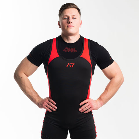 Front view of Man wearing black and red IPF approved red dawn singlet and red dawn A7 Meet t-shirt in black and red colourway. Red A7 logo on black material with red straps and side panels. The black A7 powerlifting singlet is made with premium materials and flatlock seams for maximum comfort on competition platform. 