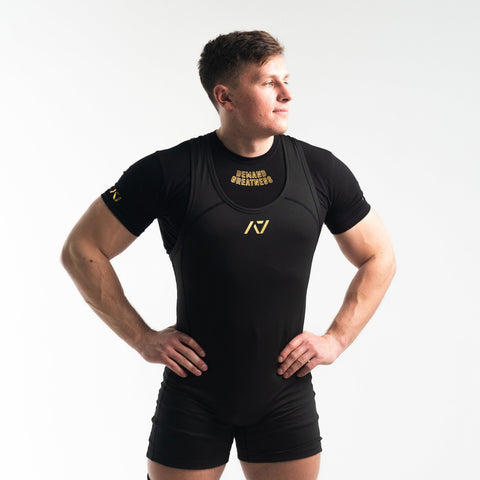 Front view of man wearing black and gold IPF approved gold singlet and gold A7 Meet t-shirt in black and gold colourway. Gold A7 logo on black material. The black A7 powerlifting singlet is made with premium materials and flatlock seams for maximum comfort on competition platform. 